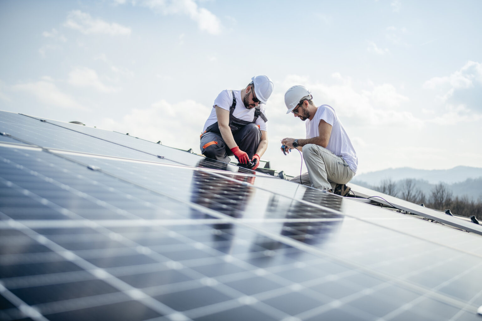 Fachleute montieren Solarmodule auf einem Dach